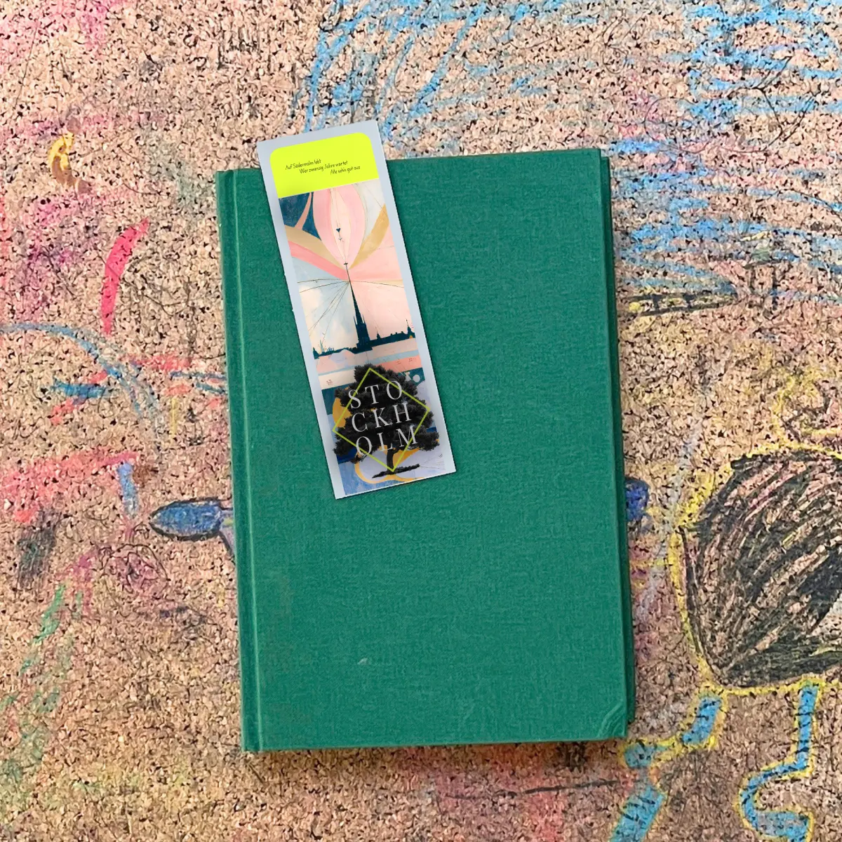Lesezeichen der Ausgabe Stockholm, auf einem Buch liegend